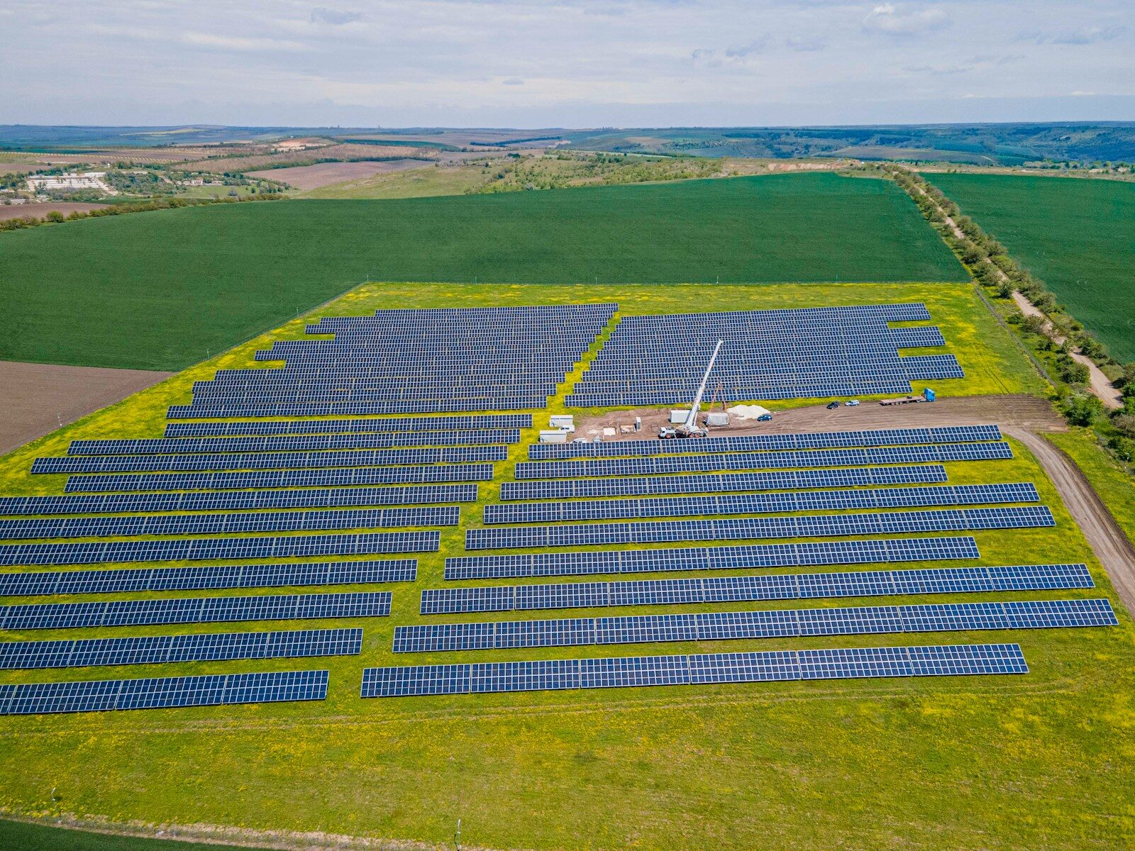 Extensive solar power plant in a vibrant green rural landscape.