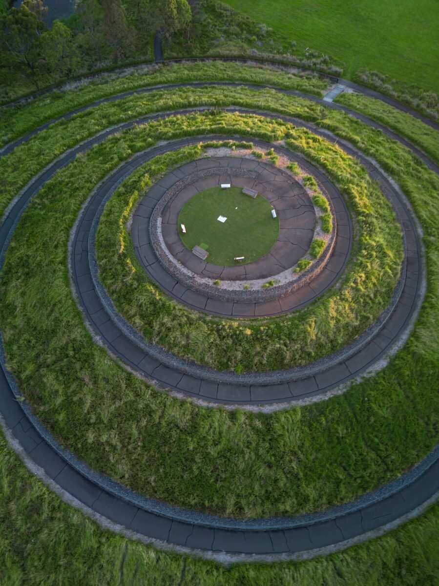 grass field and spiral pathway during day